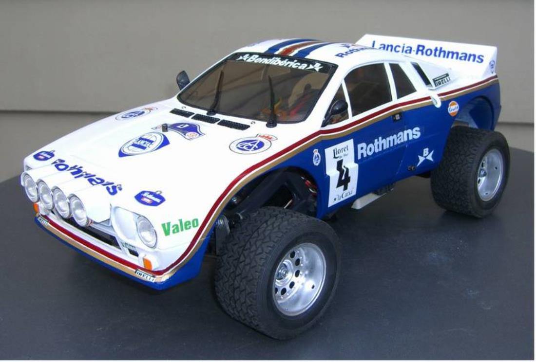 Model rally car with Rothmans livery, featuring blue, white, and red design with bold decals and large tires.